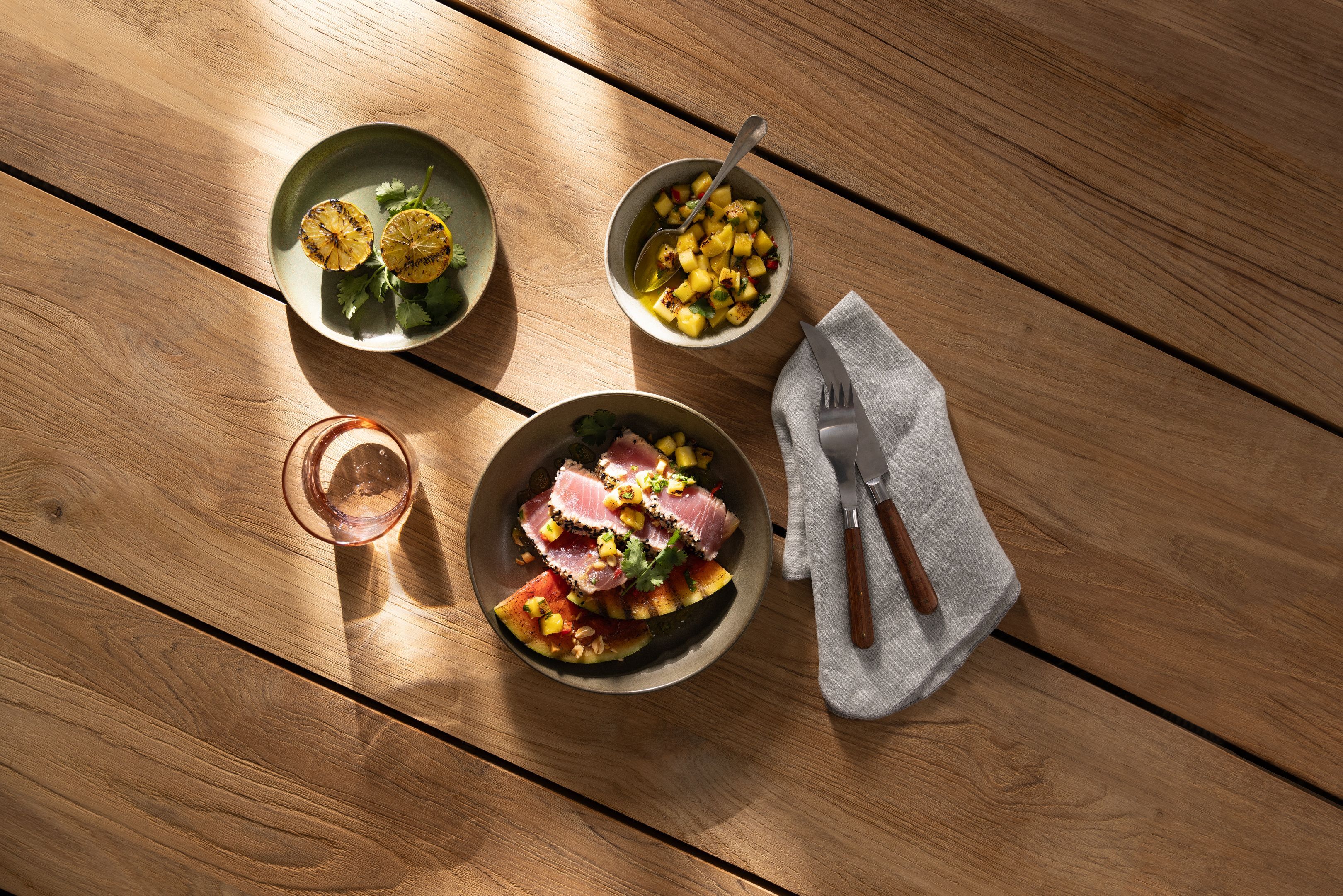 Grillgericht mit Beilagen auf Holztisch